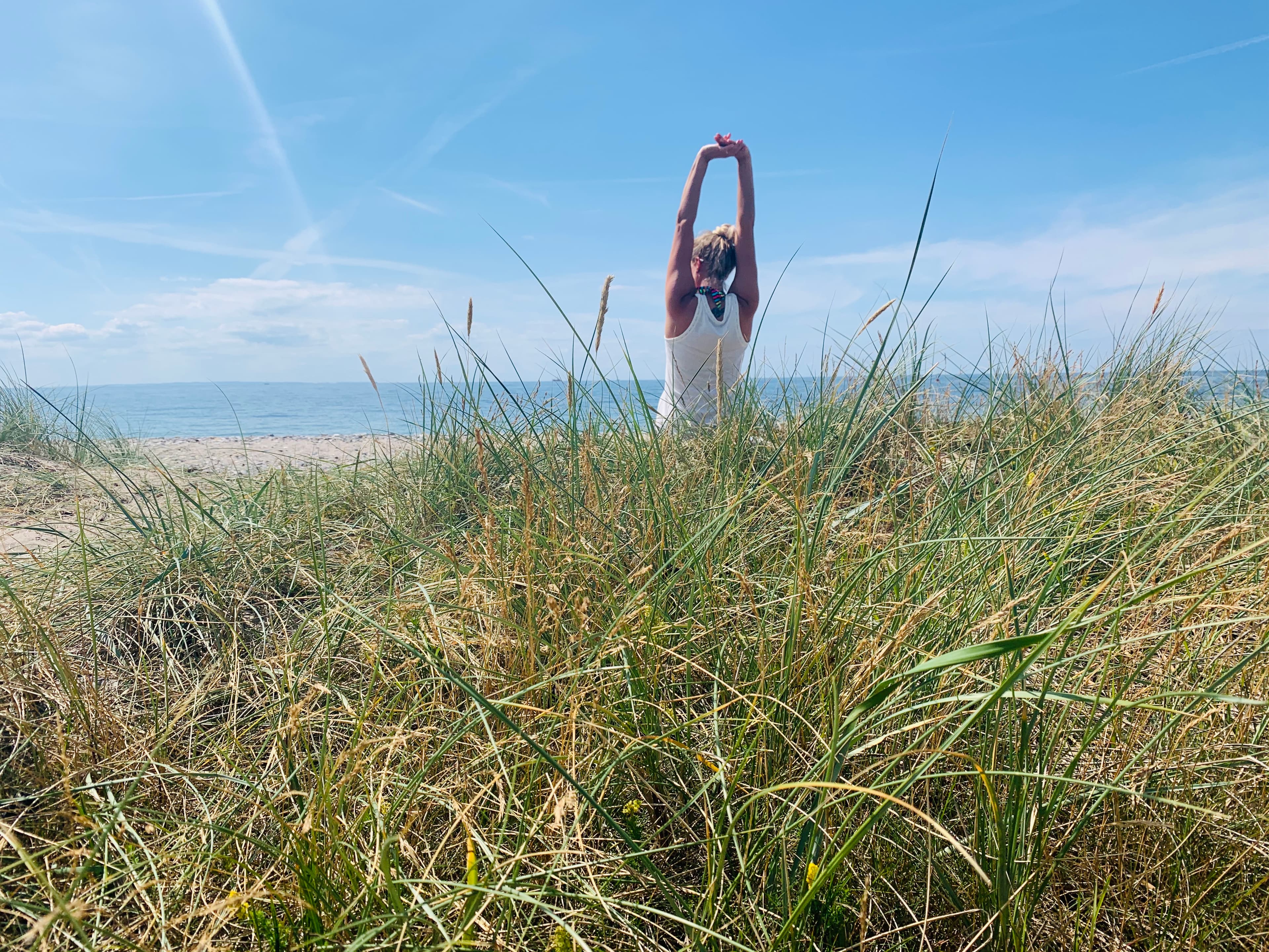 Jen übt Yoga in den Dünen am Strand